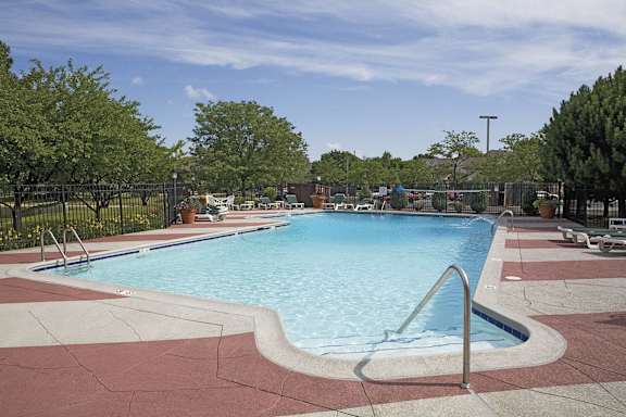 A large outdoor swimming pool surrounded by a red border.