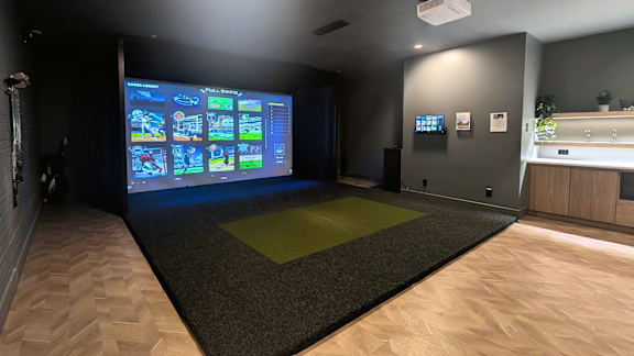 A room with a large screen displaying a video game.