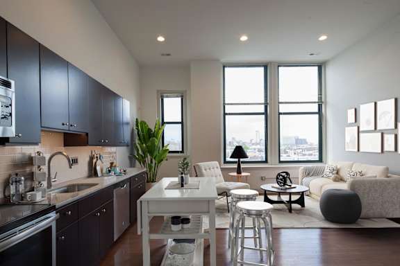 A modern kitchen with dark grey cabinets and a white island.