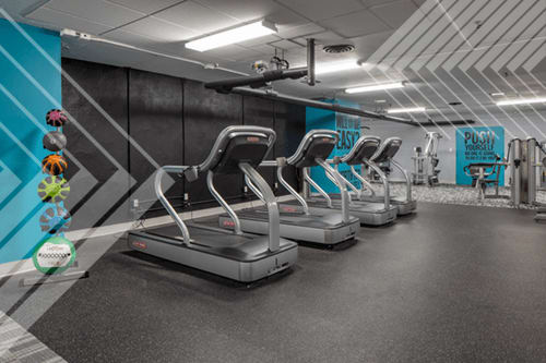 A gym with treadmills and a sign that says "PUSH".