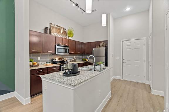 A kitchen with brown cabinets and a white island.
