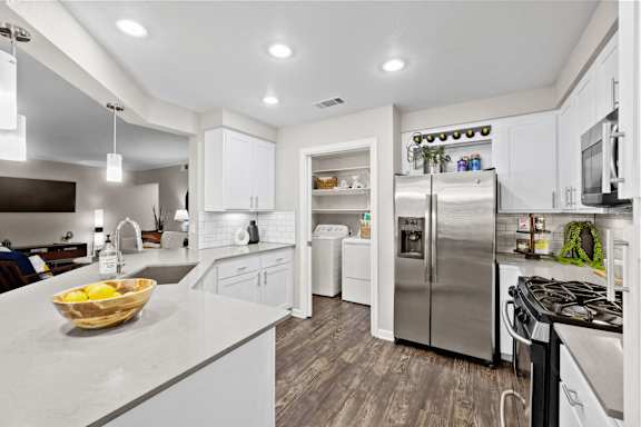 a kitchen with stainless steel appliances and white cabinets