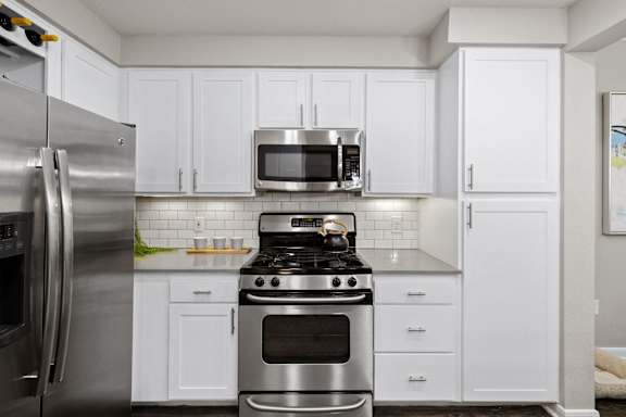 a kitchen with stainless steel appliances and white cabinets