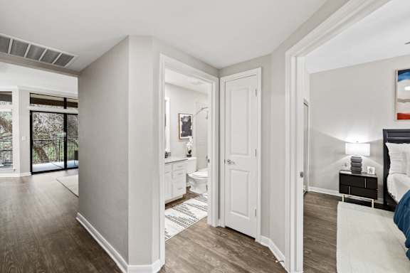 a bedroom with white walls and a door to a bathroom