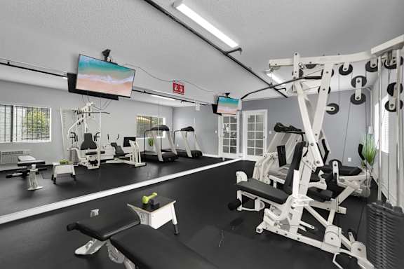 A gym with a variety of equipment including a leg press machine.