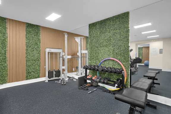 A gym with a green wall and various exercise equipment.