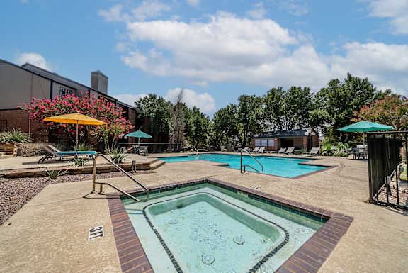 A small pool with a slide and a yellow umbrella.