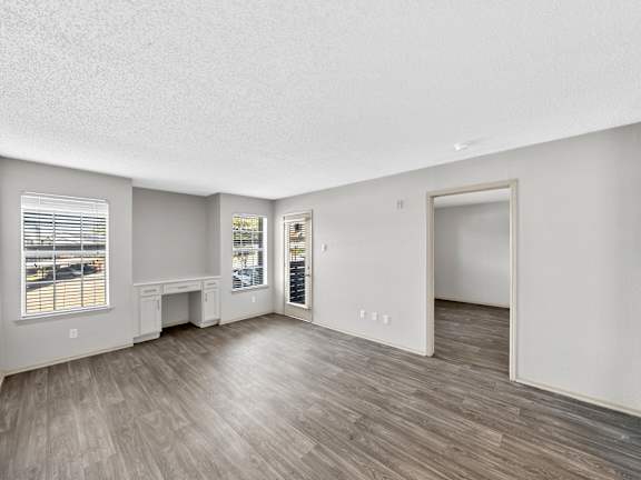 A room with a window, a desk, and a door.
