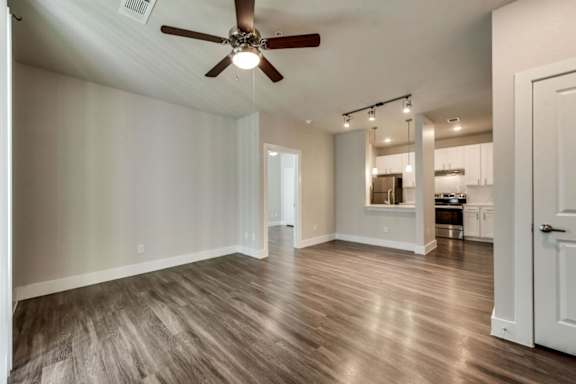 A room with a ceiling fan and wooden flooring.