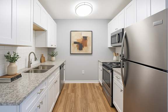 A kitchen with a refrigerator, sink, and cabinets.
