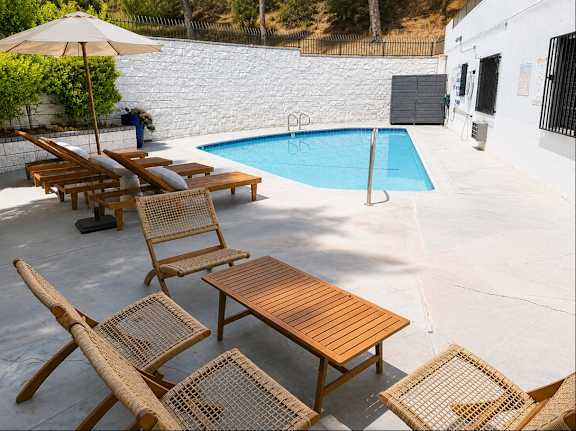 A pool with a table and chairs around it.