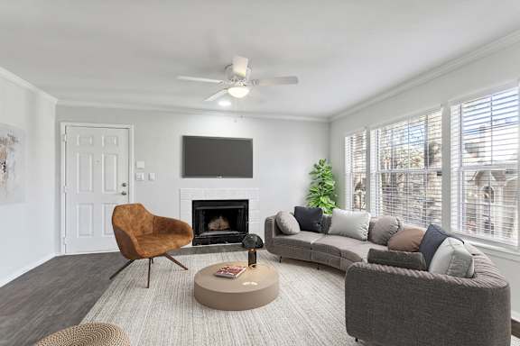 A living room with a fireplace and a television on the wall.