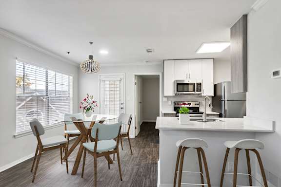 A modern kitchen with a dining table and chairs.
