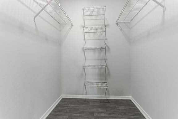 Empty room with a shelving unit and grey flooring.