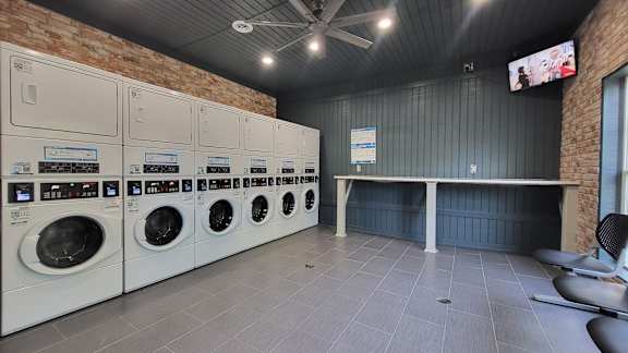 a laundry room with washers and dryers and a table