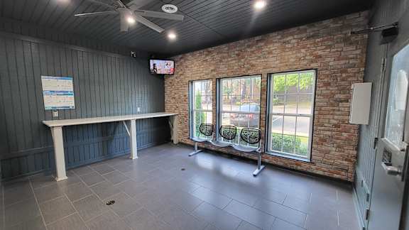 an empty room with a table and chairs and a brick wall