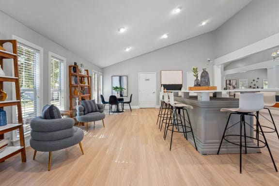 a living room with a bar and a kitchen in the back