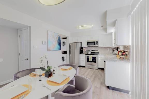 A modern kitchen with a dining table set for two.