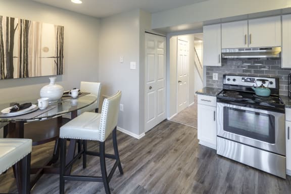 a kitchen with a stove and a table and chairs