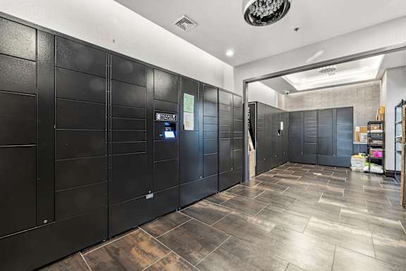 A hallway with black lockers and a wooden floor.