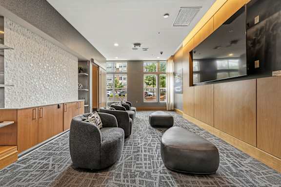 A long hallway with a row of ottomans on the floor.