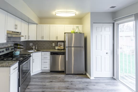 a kitchen with stainless steel appliances and white cabinets