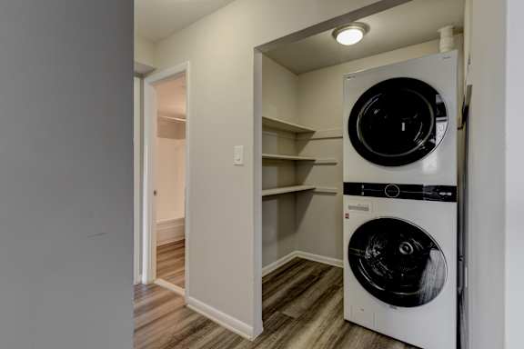 A white dryer is in a small laundry room.