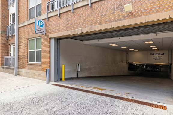 A parking garage entrance with a blue sign on the wall.