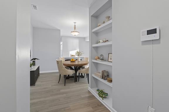 A modern dining room with a wooden table and chairs.