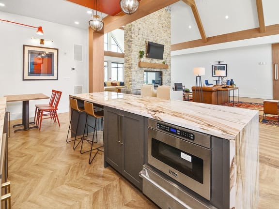 a kitchen with a large island and a living room with a fireplace