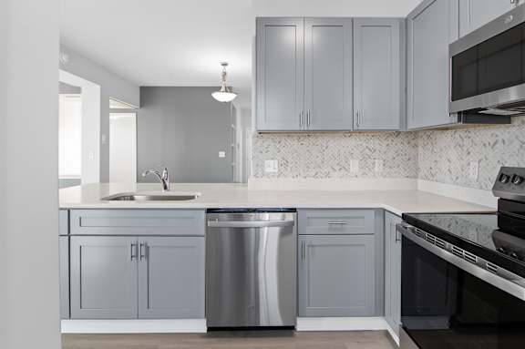 A kitchen with a sink, dishwasher, and oven.
