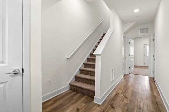A hallway with a staircase and white walls.