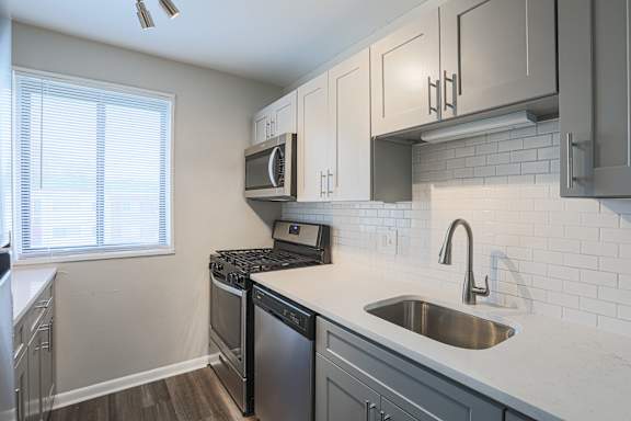 A kitchen with a stove, oven, and microwave.