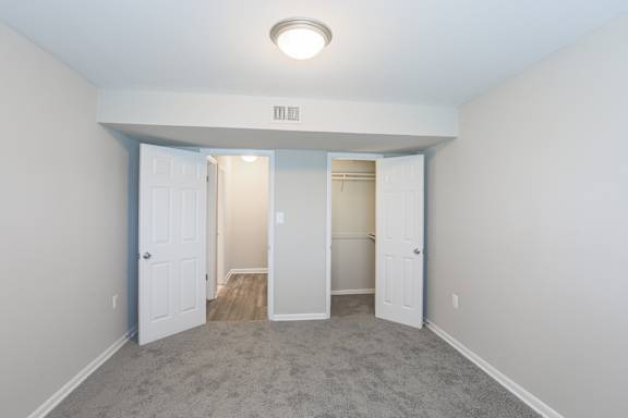A room with a carpeted floor and a ceiling light.