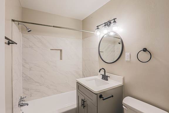 A bathroom with a white sink and a round mirror.