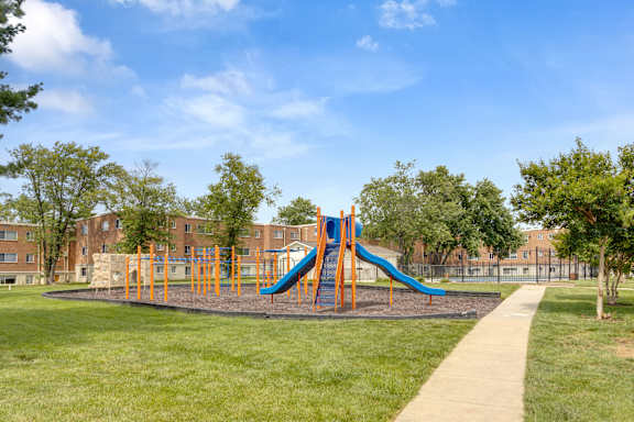 A playground with a blue and orange slide.