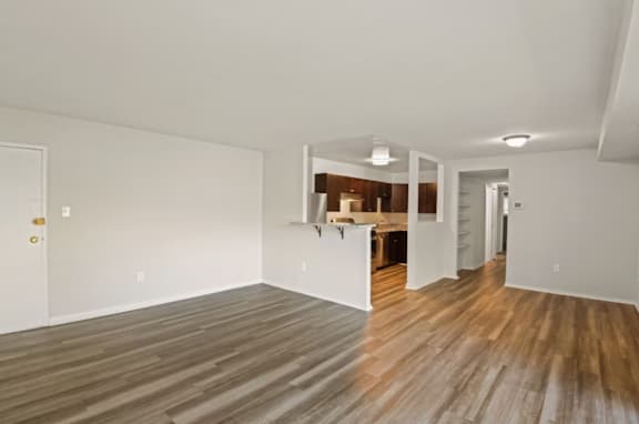 A room with wooden flooring and white walls.