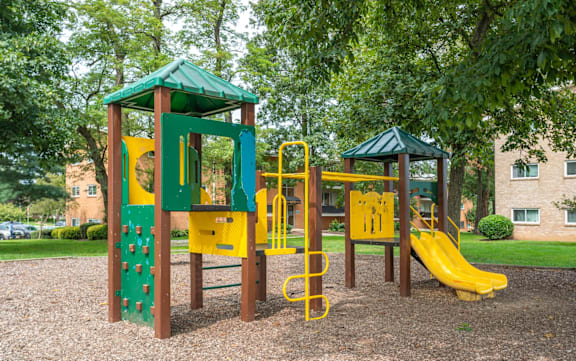 A playground with a green roof and a yellow slide.