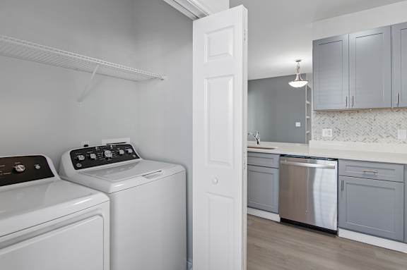 A white door is open to a kitchen.