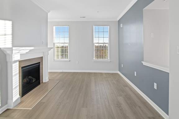 A spacious living room with a fireplace and wooden flooring.