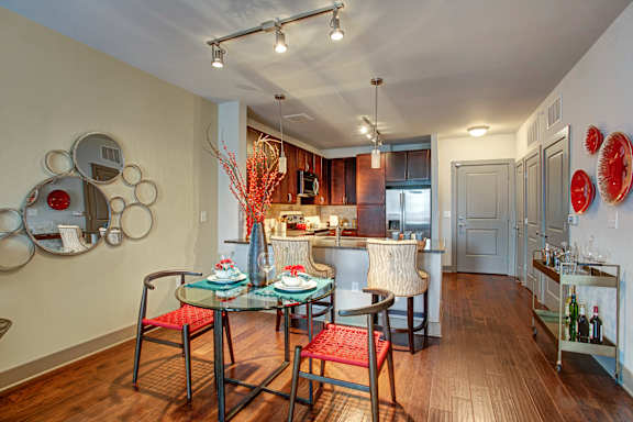 A modern dining room with a glass table and chairs.