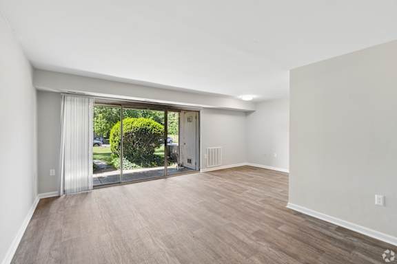 A room with a sliding glass door leading to a backyard.
