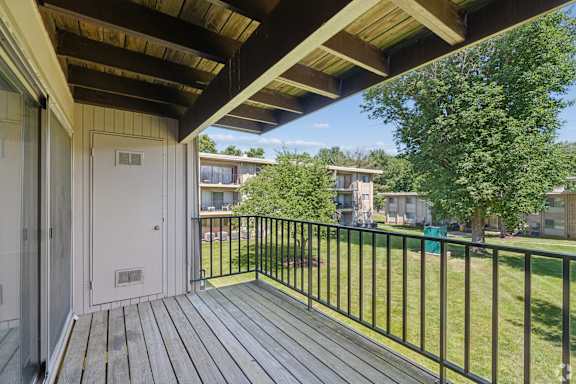 A balcony with a white door and a black railing.