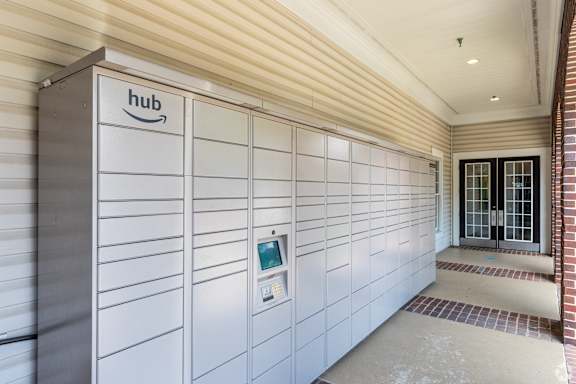 A row of Amazon lockers are lined up in a hallway.