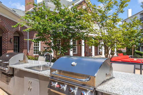 A large outdoor kitchen with a built-in grill and sink.