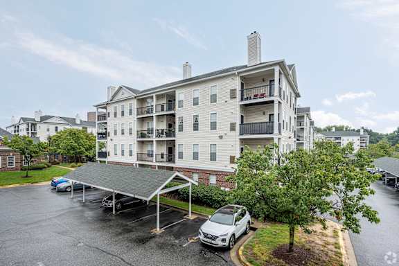 A carport is attached to a two-story apartment building.