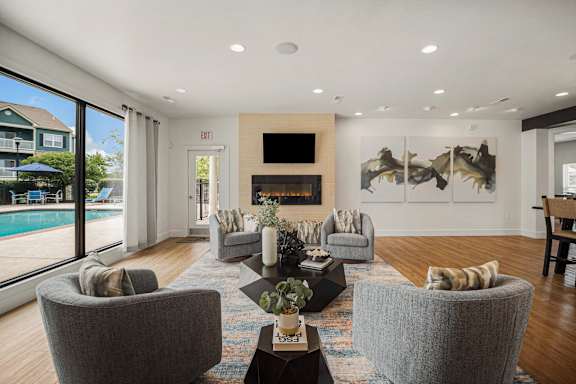 A living room with grey chairs and a fireplace.