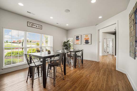 A dining room with a table and chairs.