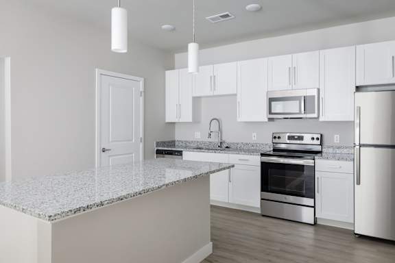 A kitchen with white cabinets and stainless steel appliances.