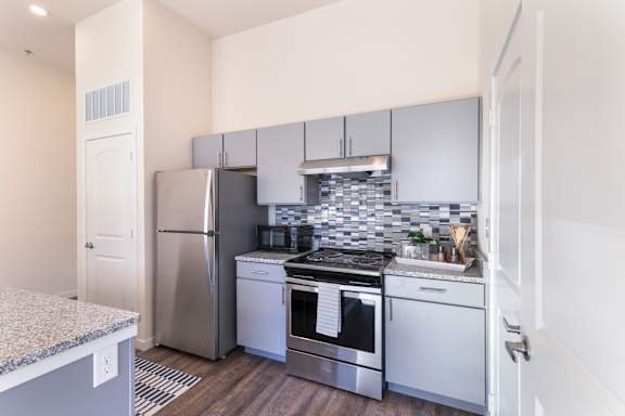 A modern kitchen with stainless steel appliances and white cabinets.